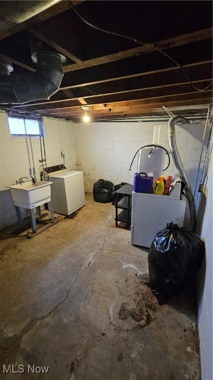 basement featuring washer / clothes dryer, sink, and refrigerator