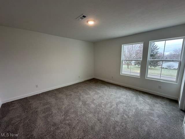 unfurnished room featuring visible vents, baseboards, carpet floors, and a textured ceiling
