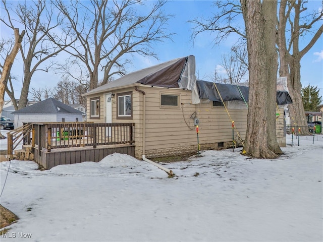 view of snowy exterior with a wooden deck