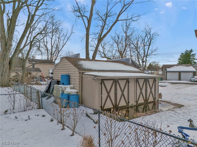 snow covered structure with a garage