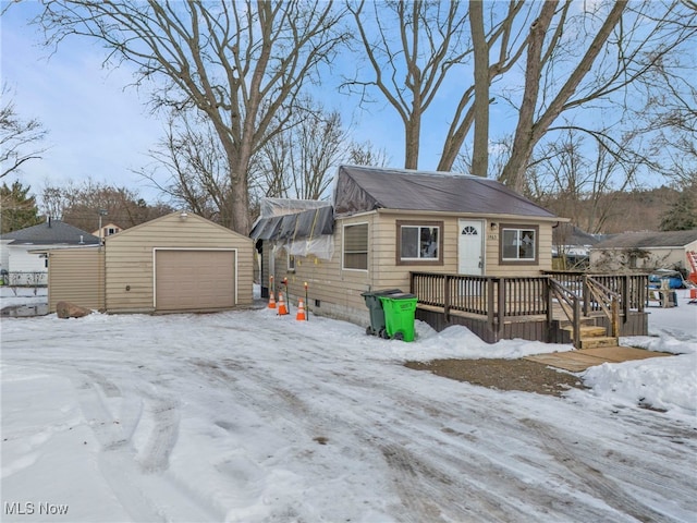 view of front of home featuring an outbuilding, a garage, and a deck