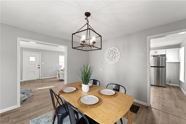 dining room featuring a notable chandelier and light hardwood / wood-style flooring