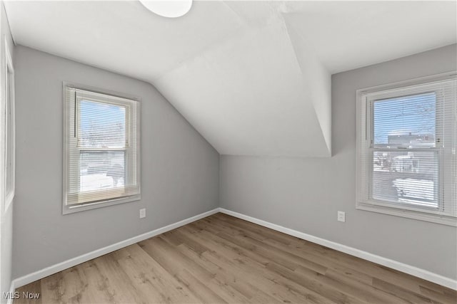 additional living space with lofted ceiling and light hardwood / wood-style flooring