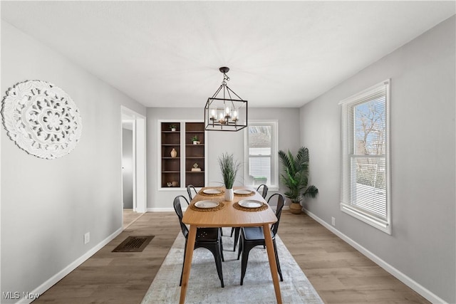 dining area featuring a notable chandelier and light hardwood / wood-style floors