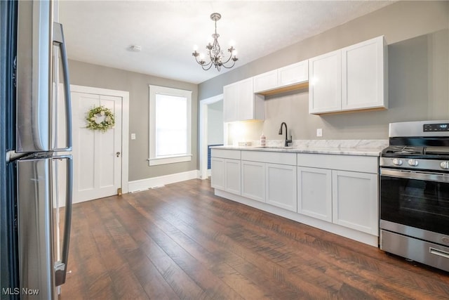 kitchen with sink, dark wood-type flooring, appliances with stainless steel finishes, white cabinetry, and light stone counters