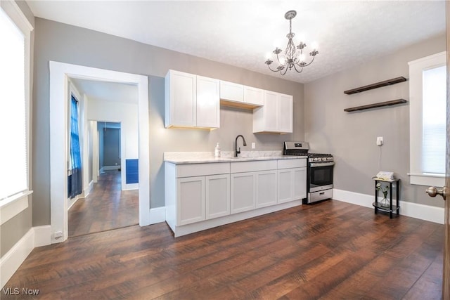 kitchen featuring white cabinetry, sink, stainless steel gas range, and dark hardwood / wood-style flooring