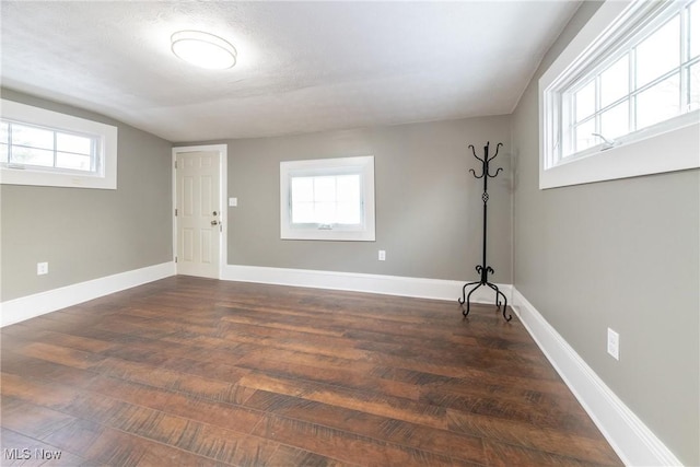 spare room with dark wood-type flooring