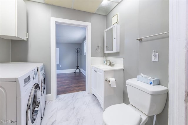 bathroom with separate washer and dryer, vanity, and toilet