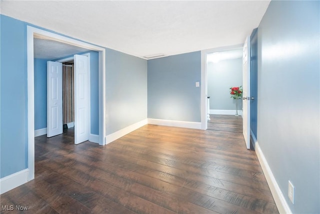 empty room with dark hardwood / wood-style flooring