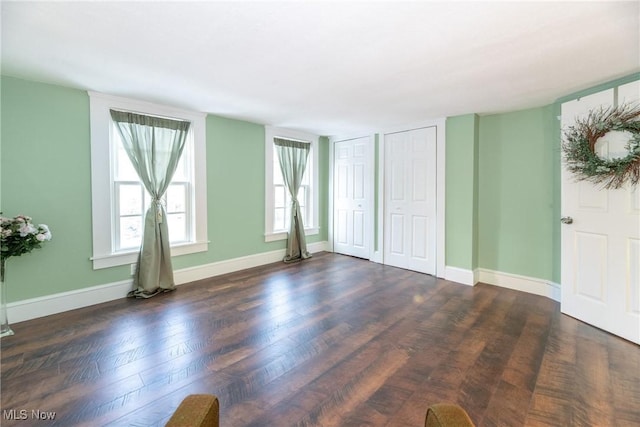 interior space featuring multiple closets and dark hardwood / wood-style flooring