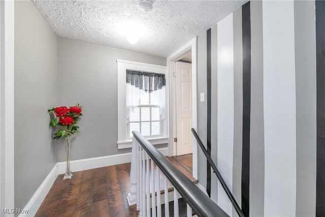 hallway featuring dark wood-type flooring and a textured ceiling