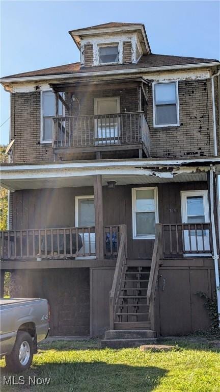 view of front of house with a front lawn and a balcony