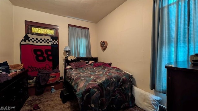 bedroom featuring lofted ceiling and carpet flooring