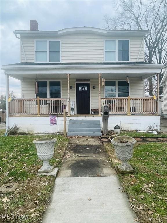 view of front of property with covered porch and a front yard