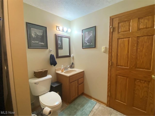 bathroom featuring vanity, toilet, and a textured ceiling