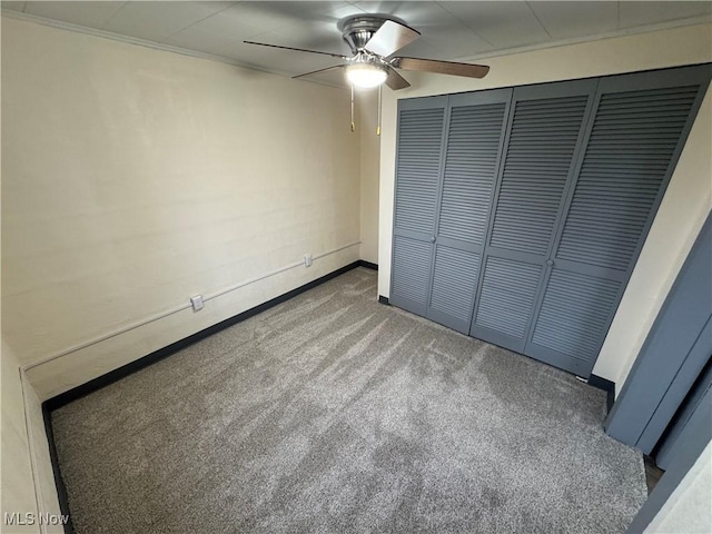 unfurnished bedroom featuring ceiling fan, a closet, and carpet