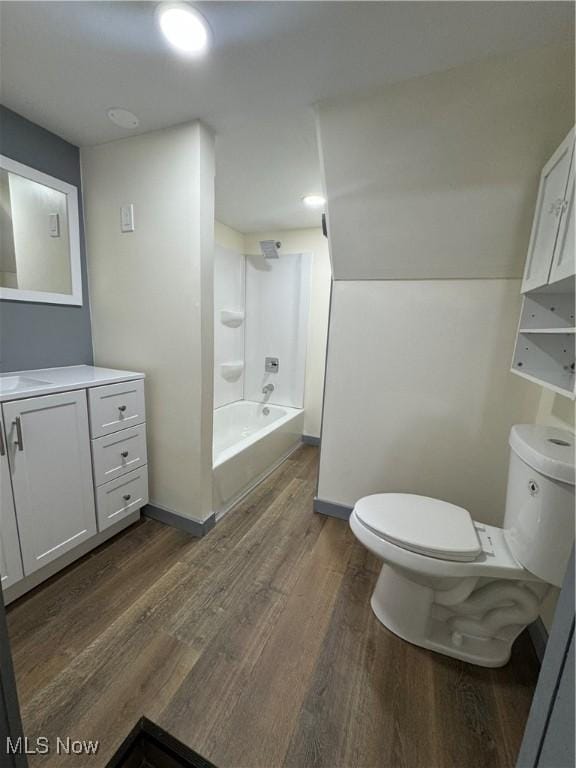 full bathroom with washtub / shower combination, wood-type flooring, toilet, and vanity