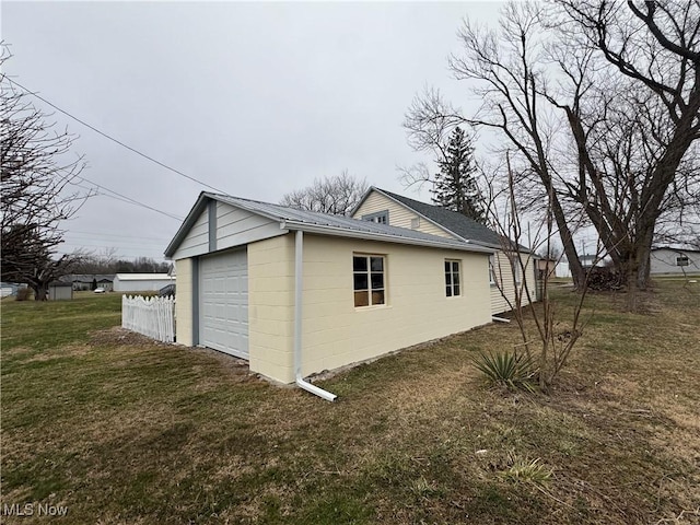 view of side of property with a garage, a lawn, and an outdoor structure