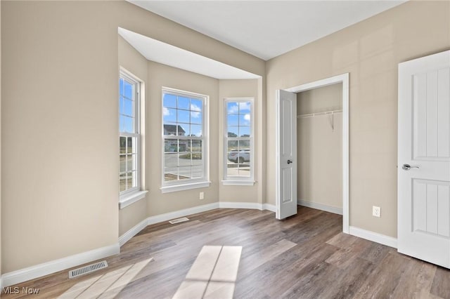 unfurnished bedroom with light wood-type flooring and a closet