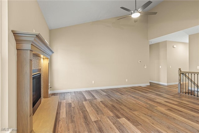 unfurnished living room with ceiling fan, high vaulted ceiling, and light hardwood / wood-style floors