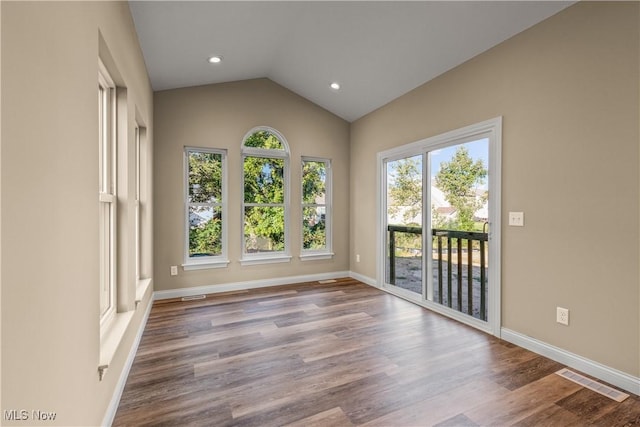 unfurnished room featuring vaulted ceiling and light hardwood / wood-style flooring