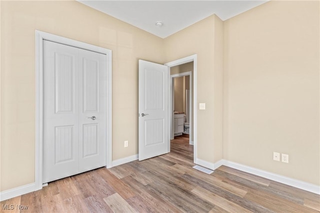 unfurnished bedroom featuring light hardwood / wood-style floors and a closet