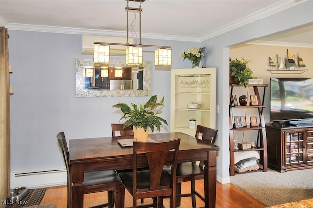 dining area featuring wood-type flooring, a baseboard heating unit, and crown molding