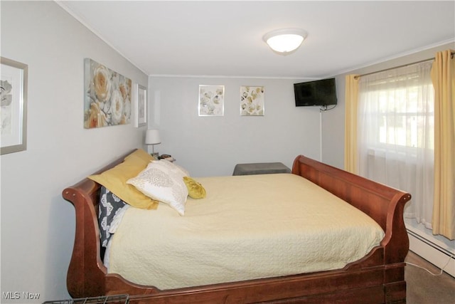 bedroom featuring crown molding and baseboard heating