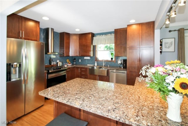 kitchen featuring wall chimney range hood, a kitchen breakfast bar, kitchen peninsula, and appliances with stainless steel finishes