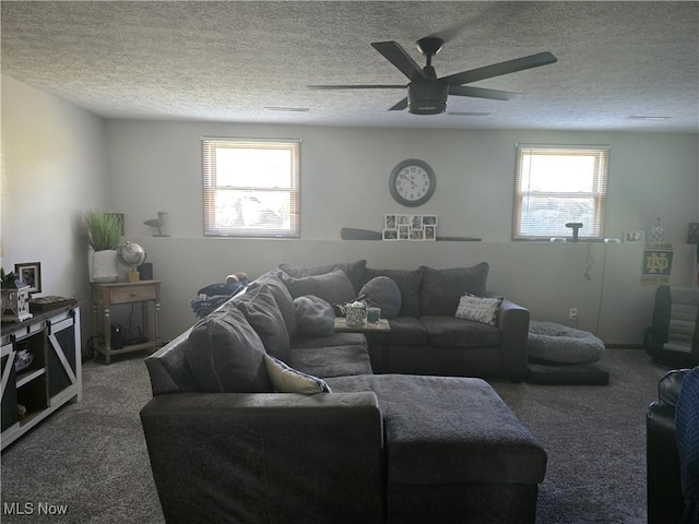 living room featuring ceiling fan, a textured ceiling, a healthy amount of sunlight, and carpet