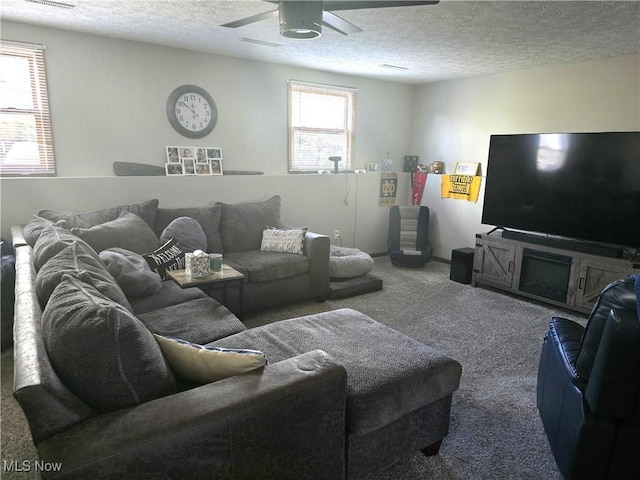 carpeted living room with a textured ceiling and ceiling fan