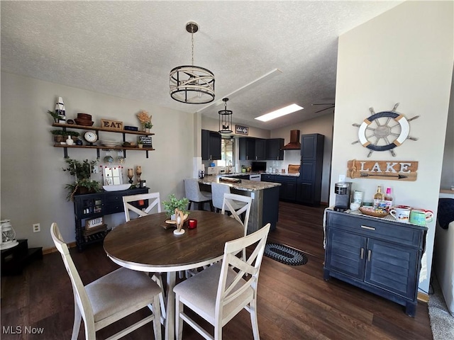 dining space featuring sink, a textured ceiling, dark wood-type flooring, and vaulted ceiling with skylight