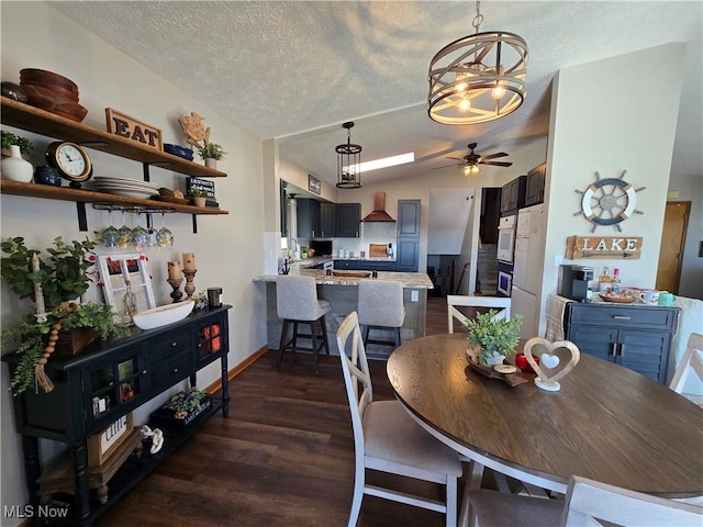 dining space featuring dark hardwood / wood-style flooring, ceiling fan, lofted ceiling, and a textured ceiling