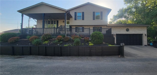 tri-level home featuring a garage, covered porch, and ceiling fan