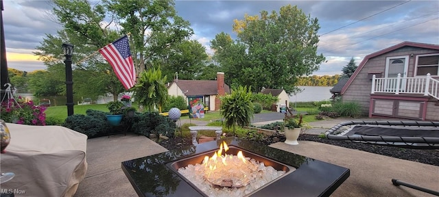 patio terrace at dusk featuring a fire pit