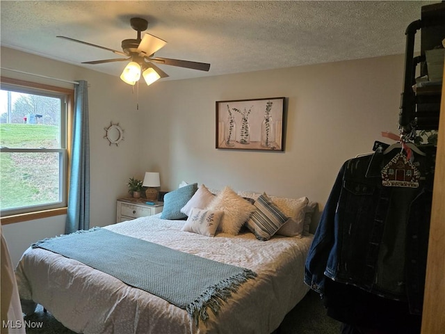 bedroom featuring ceiling fan and a textured ceiling