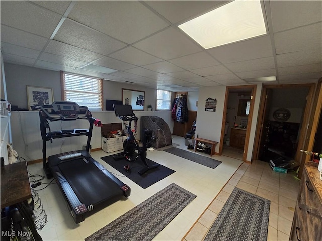 exercise room featuring a paneled ceiling and tile patterned floors