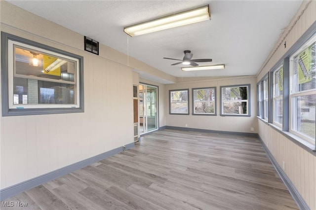 unfurnished sunroom with plenty of natural light and ceiling fan