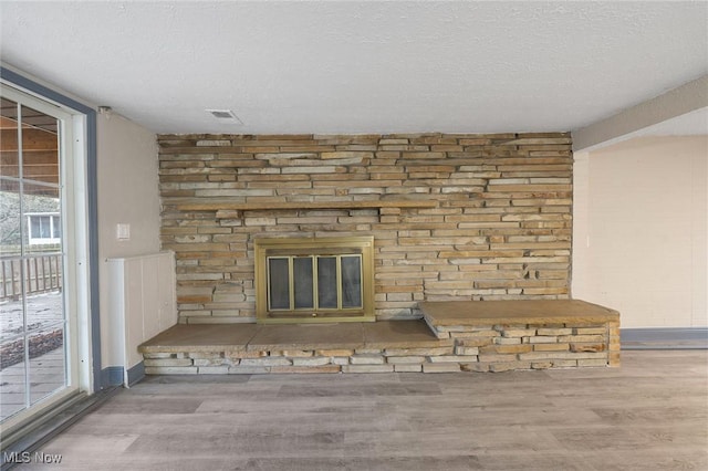 details featuring a large fireplace, hardwood / wood-style floors, and a textured ceiling