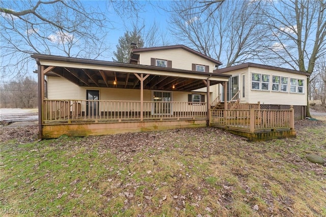 back of property featuring a wooden deck and a sunroom