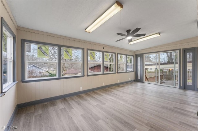 unfurnished sunroom with ceiling fan