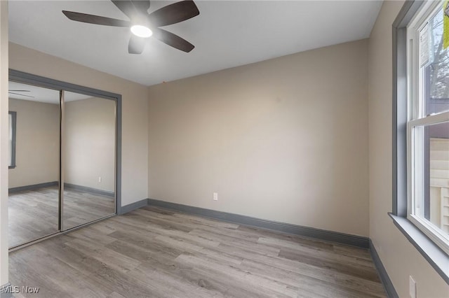 unfurnished bedroom featuring a closet, ceiling fan, and light wood-type flooring