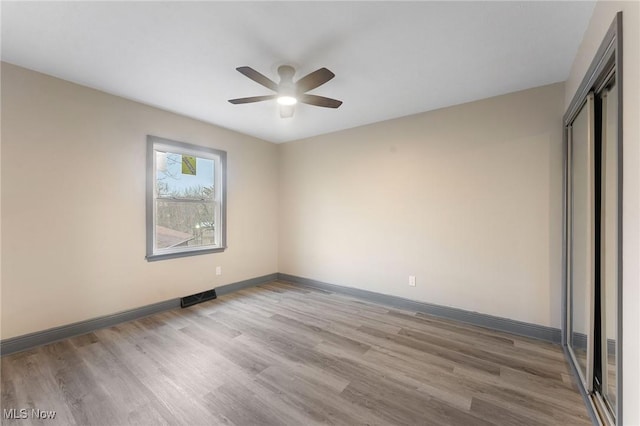 unfurnished bedroom featuring light hardwood / wood-style flooring, a closet, and ceiling fan