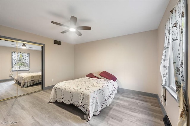 bedroom featuring light hardwood / wood-style flooring, a closet, and ceiling fan