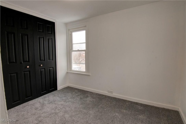 unfurnished bedroom with a closet and carpet