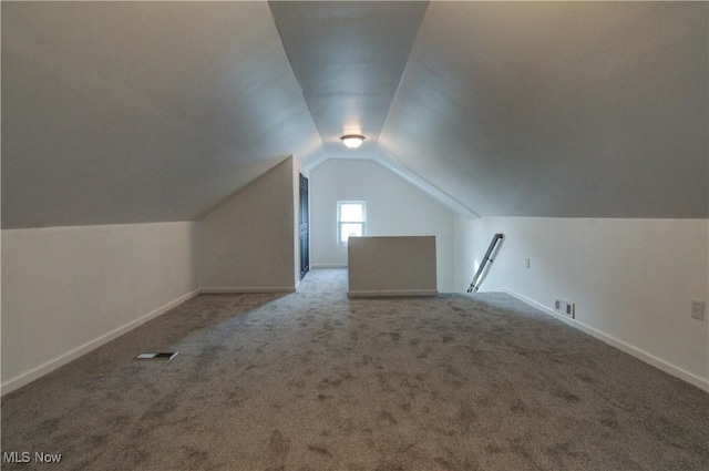 bonus room with lofted ceiling and carpet flooring