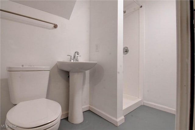 bathroom with concrete flooring, toilet, and walk in shower