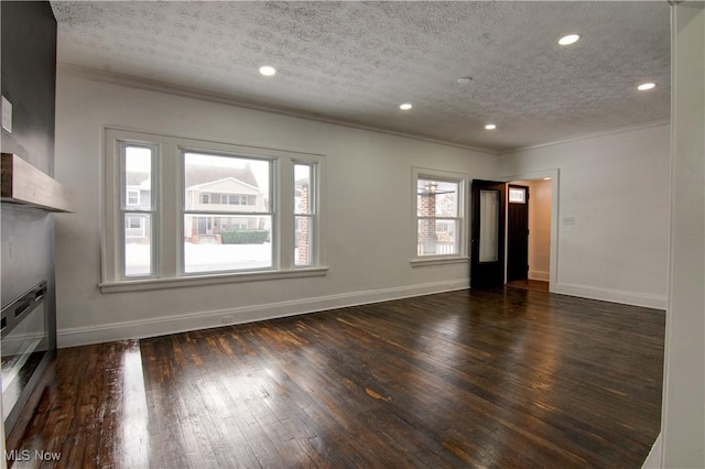 unfurnished living room featuring dark hardwood / wood-style flooring, ornamental molding, and a textured ceiling