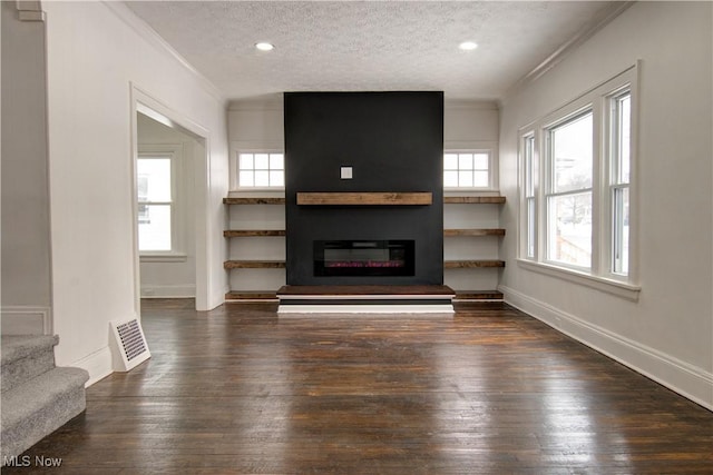 unfurnished living room featuring crown molding, dark hardwood / wood-style flooring, and a textured ceiling