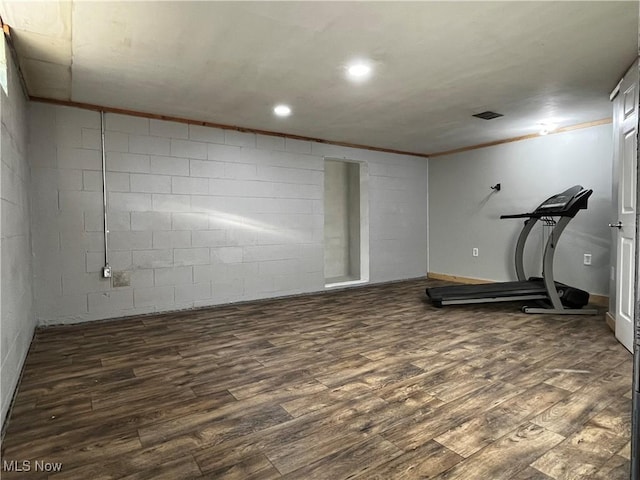 workout area featuring crown molding and dark wood-type flooring